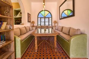 a living room with a couch and a table at Villa Nouran - Chambre D'Hôte in Ghazoua