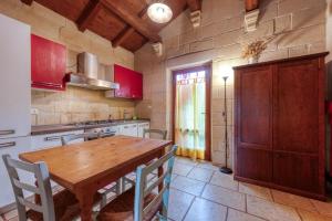 a kitchen with a wooden table and a wooden cabinet at Masseria Copertini in Vernole