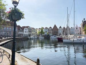 a street light next to a canal with boats at Studio Watertoren in Goes