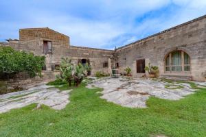 an old stone building with a grass yard at Masseria Copertini in Vernole