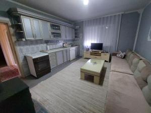 a living room with a couch and a table in a kitchen at Ariana Guest House in Prizren +6 photos
