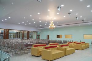 a large banquet hall with chairs and a chandelier at Sri Laxmi Grand Convention in Tuni