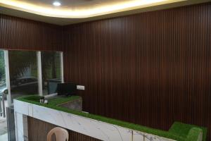 a lobby with a red wall with a green counter at Sri Laxmi Grand Convention in Tuni