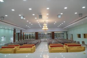 a large room with rows of chairs and a chandelier at Sri Laxmi Grand Convention in Tuni