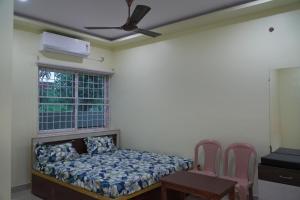 a bedroom with a bed and a window at Sri Laxmi Grand Convention in Tuni