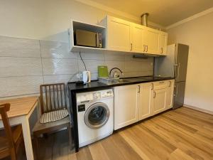a kitchen with a washing machine and a microwave at Na Papierni in Klucze