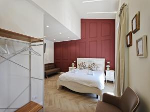 a bedroom with a bed and a red wall at La Dimora delle Muse in Sulmona