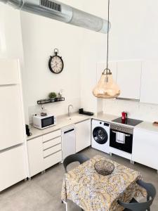 a kitchen with a table and a clock on the wall at Jardín Viveros-Turia in Valencia