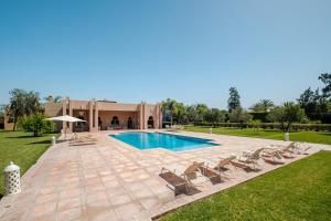 a swimming pool with chairs and a house at Luxury Palace in Marrakesh in Marrakesh