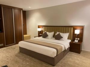 a hotel room with a large bed with two night stands at شقق الآجنحة التنفيذية للشقق المخدومة in Riyadh +52 photos