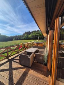 a patio with a table and chairs on a deck at Domek w Skolitach in Skolity