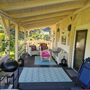 a porch with white furniture and a wooden ceiling at Domek nad Brennicą in Brenna