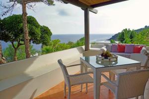 a patio with a table and chairs and the ocean at Dammuso Vento Del Sud in Pantelleria
