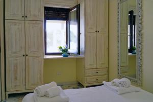 a bedroom with two beds and a mirror and a window at Dammuso Vento Del Sud in Pantelleria
