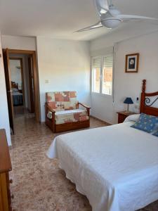 a bedroom with a large white bed and a couch at Apartamento vacacional Jávea in Jávea