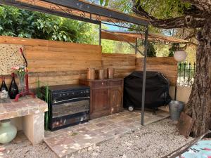 an outdoor kitchen with a table and a stove at Mas des garrigues in Bouchet