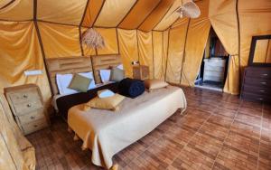 a bedroom with a bed in a tent at Merzouga Retreat Camp in Merzouga