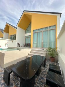 a house with a swimming pool and a patio at Rimna Pool Villa in Hat Yai