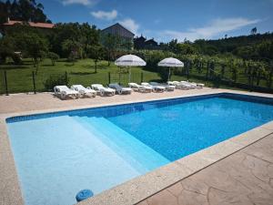 a swimming pool with lounge chairs and umbrellas at Casa de Crabera in Dodro