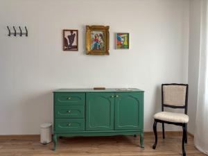 a green cabinet and a chair in a room at Dabfly Guesthouse & Outdoor Adventures in Ražanj
