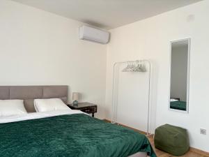 a bedroom with a green bed and a mirror at Dabfly Guesthouse & Outdoor Adventures in Ražanj