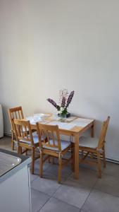 a wooden table with chairs and a vase of flowers on it at Old Town Apartment Opole in Opole