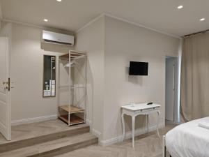 a white room with a bed and a table and a tv at La Dimora delle Muse in Sulmona +63 photos