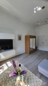 a living room with a couch and a table with flowers at Old Town Apartment Opole in Opole