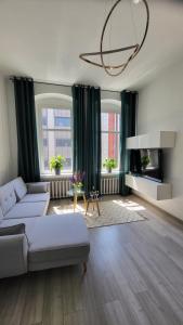 a living room with a couch and a tv at Old Town Apartment Opole in Opole