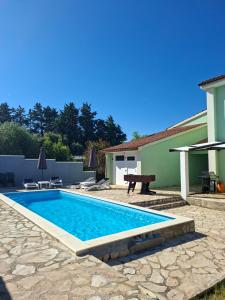 a swimming pool in front of a house at vila lokvanj in Ližnjan