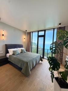 a bedroom with a bed and a large window at Modern Villa - infinity pool & Panoramic Sea View in Kvariati +24 photos