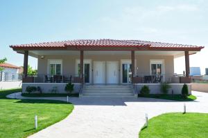 a small house with a porch and grass at Pella Luxury Archonta in Pélla