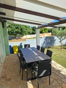 a table and chairs under awning on a patio at vila lokvanj in Ližnjan