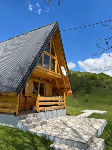 a log cabin with a stone walkway in front of it at Etno village Bare in Bare