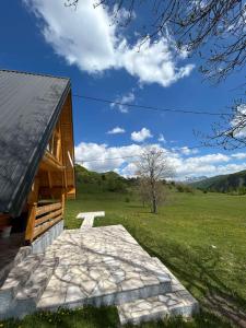 a building with a stone walkway next to a field at Etno village Bare in Bare