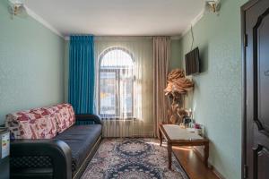 a living room with a couch and a table at Tashrabat Hotel in Karakol +50 photos