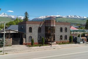 a brick building on the side of a street at Tashrabat Hotel in Karakol