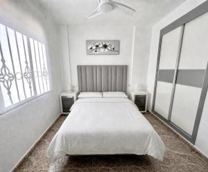 a white bedroom with a large bed and windows at La Macarena Torrevieja in Torrevieja +19 photos