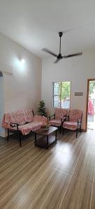 a living room with two couches and a table at Parisian Evenings Homestay - Madurai in Madurai