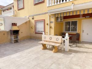a bench sitting outside of a building with a fireplace at La Macarena Torrevieja in Torrevieja