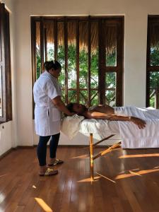 a woman standing next to a man laying on a bed at Surfbreak Cabarete in Cabarete