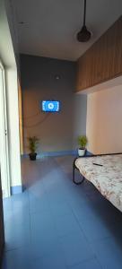 an empty room with a television on the wall at Parisian Evenings Homestay - Madurai in Madurai