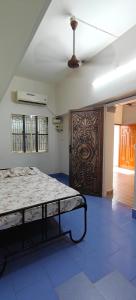a bedroom with a bed and a large wooden door at Parisian Evenings Homestay - Madurai in Madurai