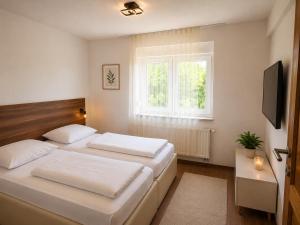 a bedroom with two beds and a window at Grabovica Sobe-Blue Lake Luxury Rooms in Grabovica