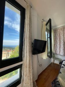 a room with a window with a television and a bed at Blue House 2 in Paliouri