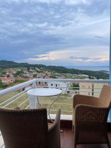 a balcony with two chairs and a table on a balcony at Blue House 2 in Paliouri
