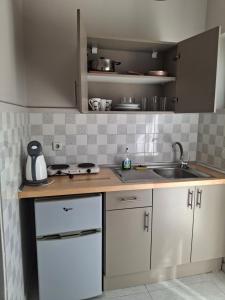 a kitchen with white cabinets and a sink at Giannis Studios in Alykes