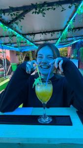 a woman sitting at a table drinking a drink at The Hood Hostel & Day Tours in Shkodër