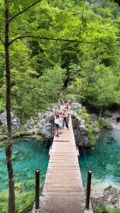 a group of people crossing a wooden bridge over a river at The Hood Hostel & Day Tours in Shkodër