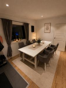 a dining room with a white table and chairs at Mysig stuga i Nävesta in Örebro +17 photos